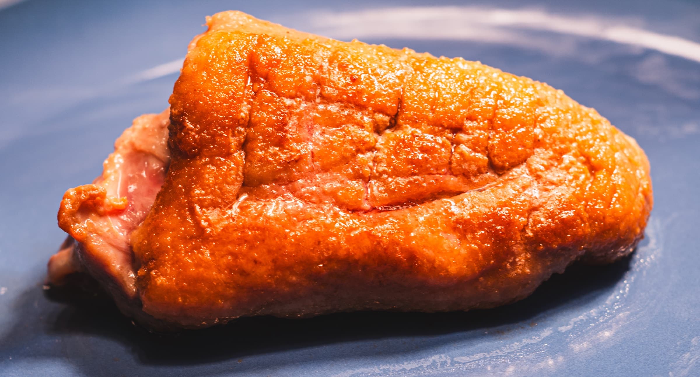 Close-up of pan-seared meat with crispy golden-brown skin