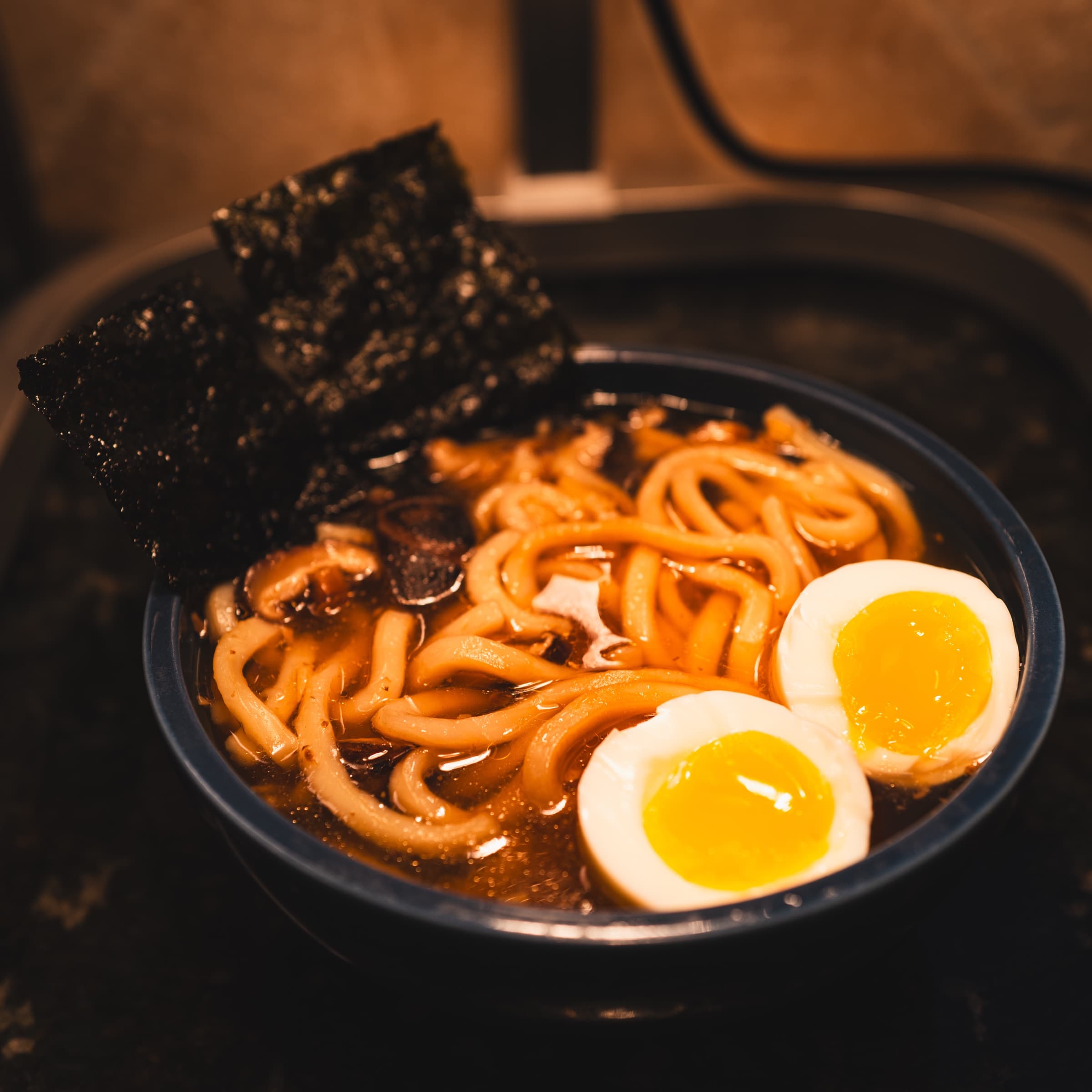 Bowl of ramen with a jammy egg, mushrooms, and nori